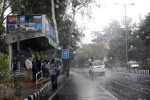 New Delhi: People take shelter under a bus stop to prevent themselves from winter rains, in New Delhi, on Jan 2, 2015. (Photo: Amlan Paliwal/IANS)